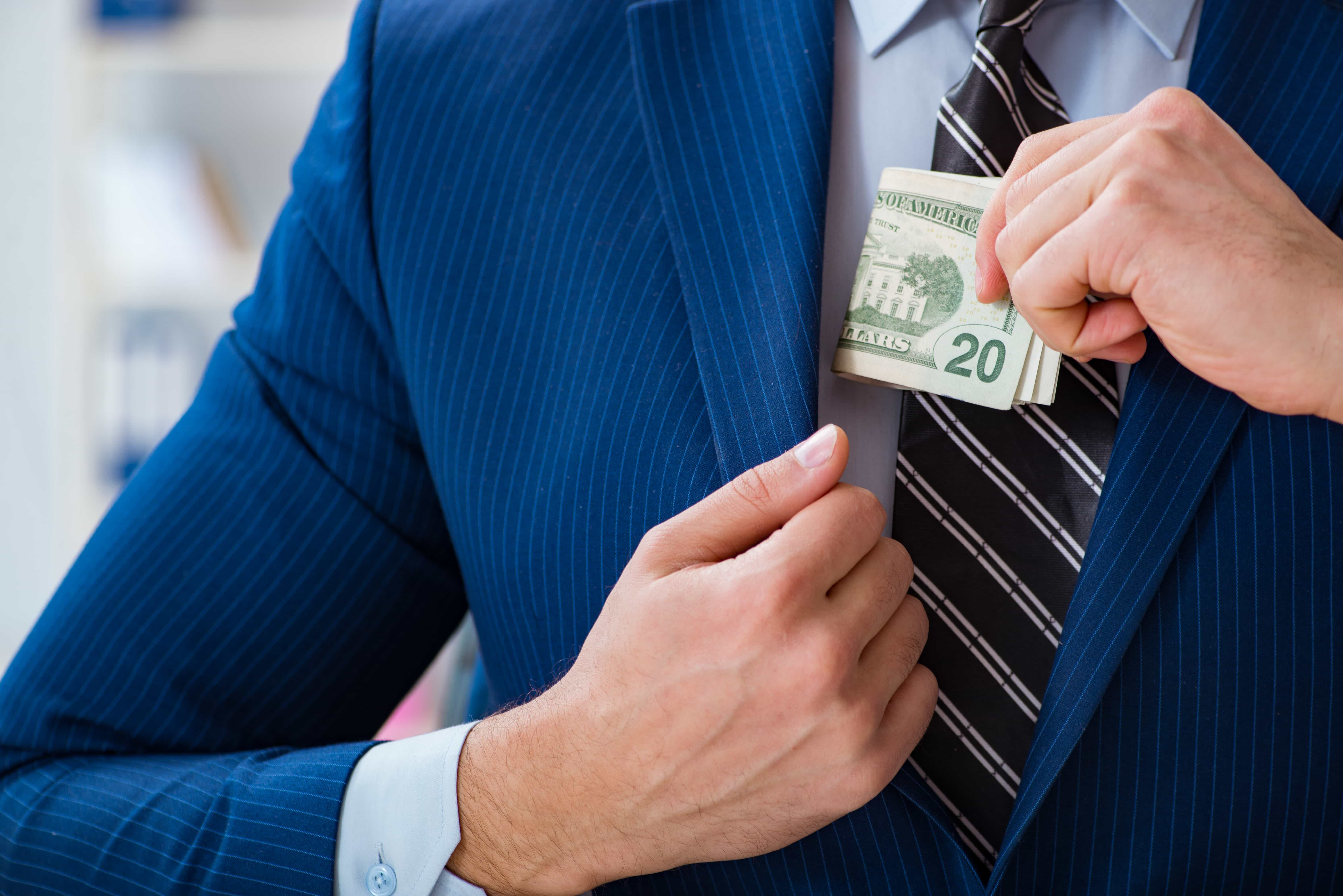 man putting money in a suit